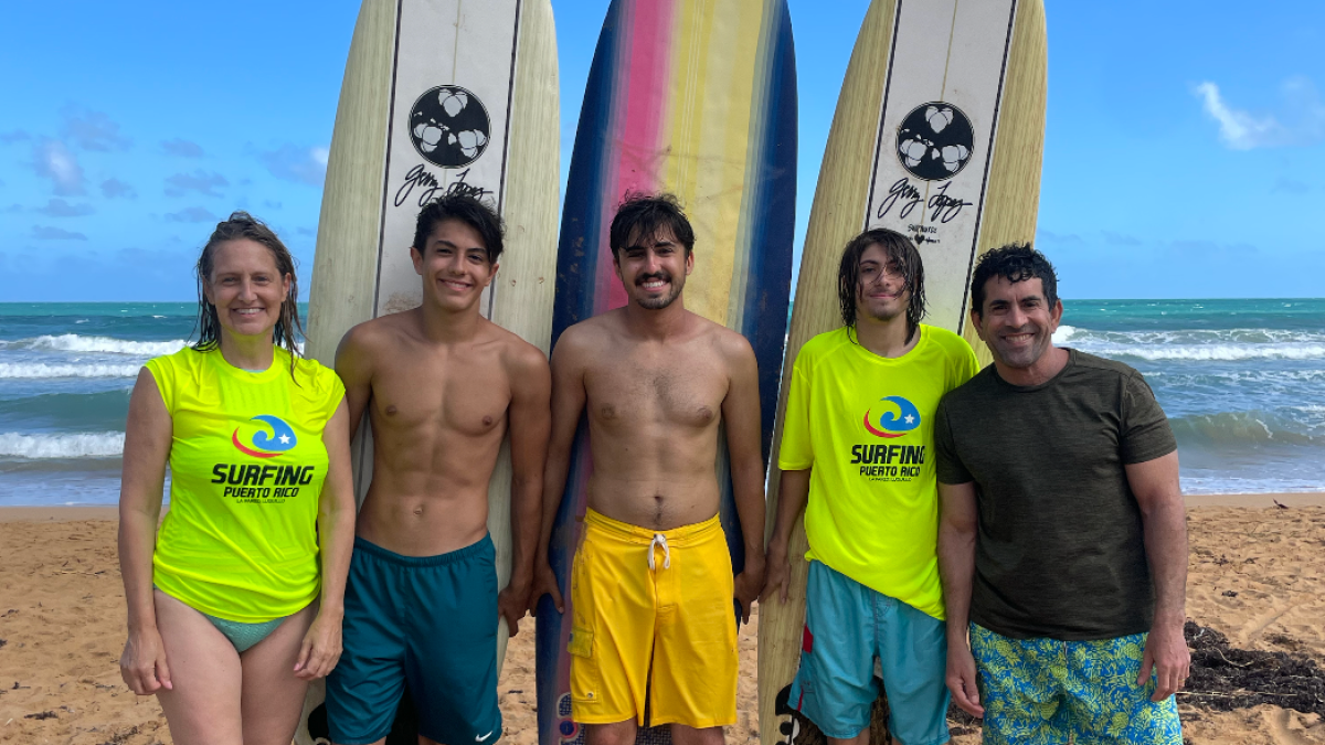 a group of people standing on a beach posing for the camera