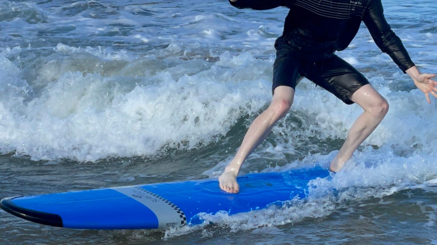 a young girl riding a wave on a surfboard in the ocean