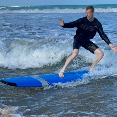 a young girl riding a wave on a surfboard in the ocean