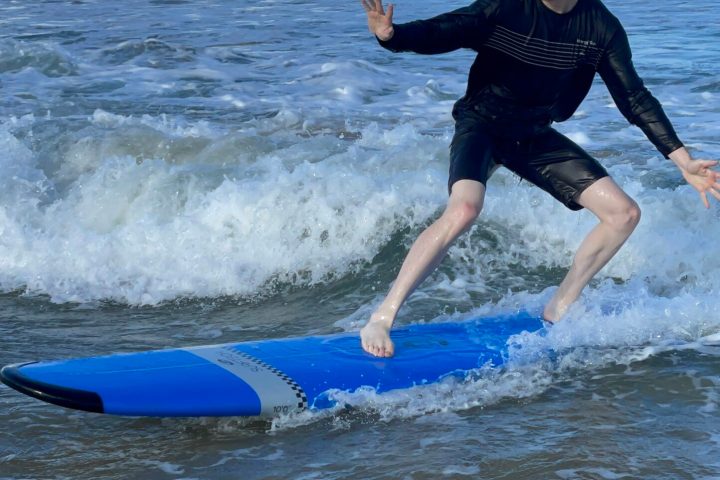 a young girl riding a wave on a surfboard in the ocean