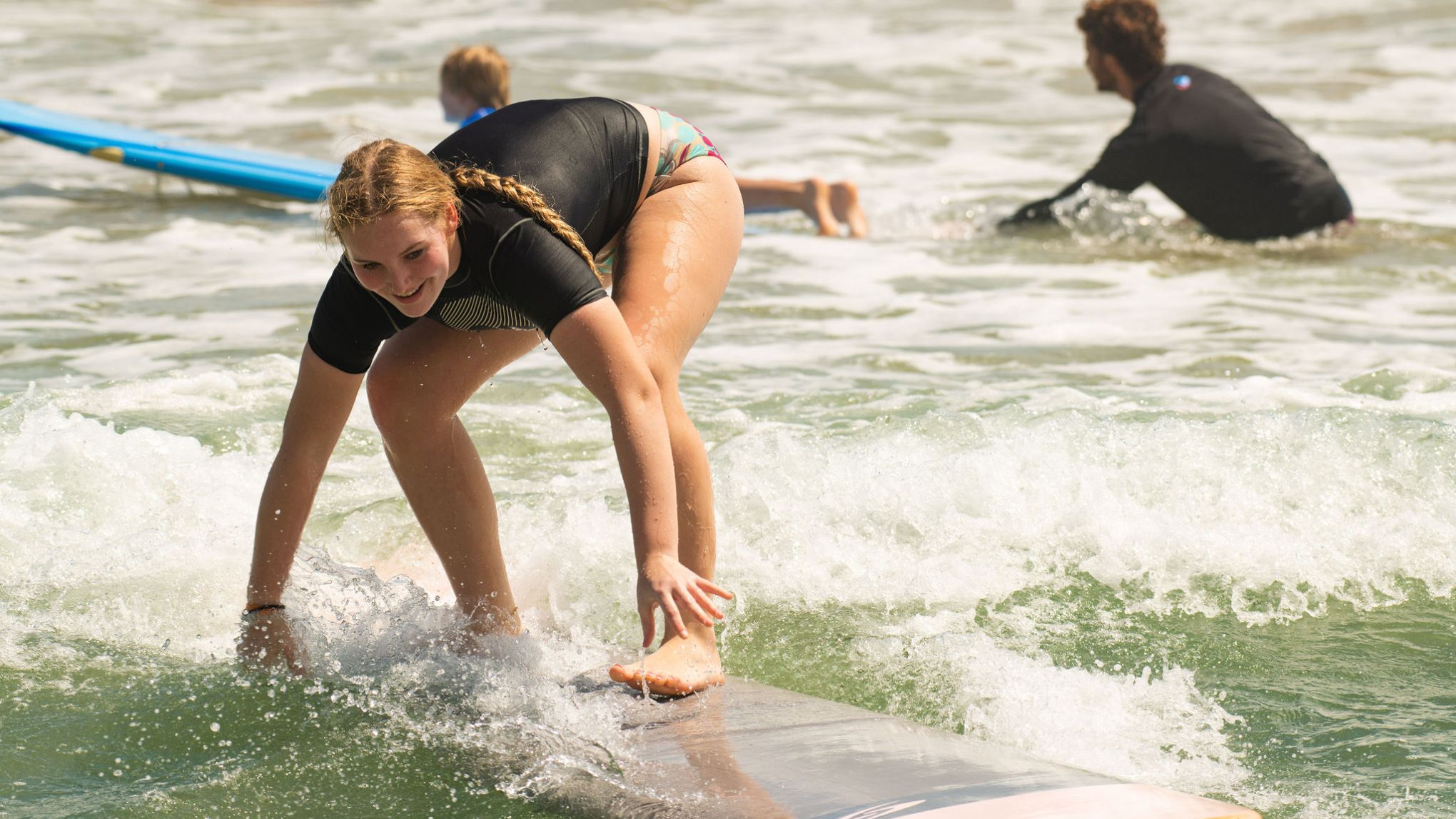 a young girl riding a wave on a surfboard in the water