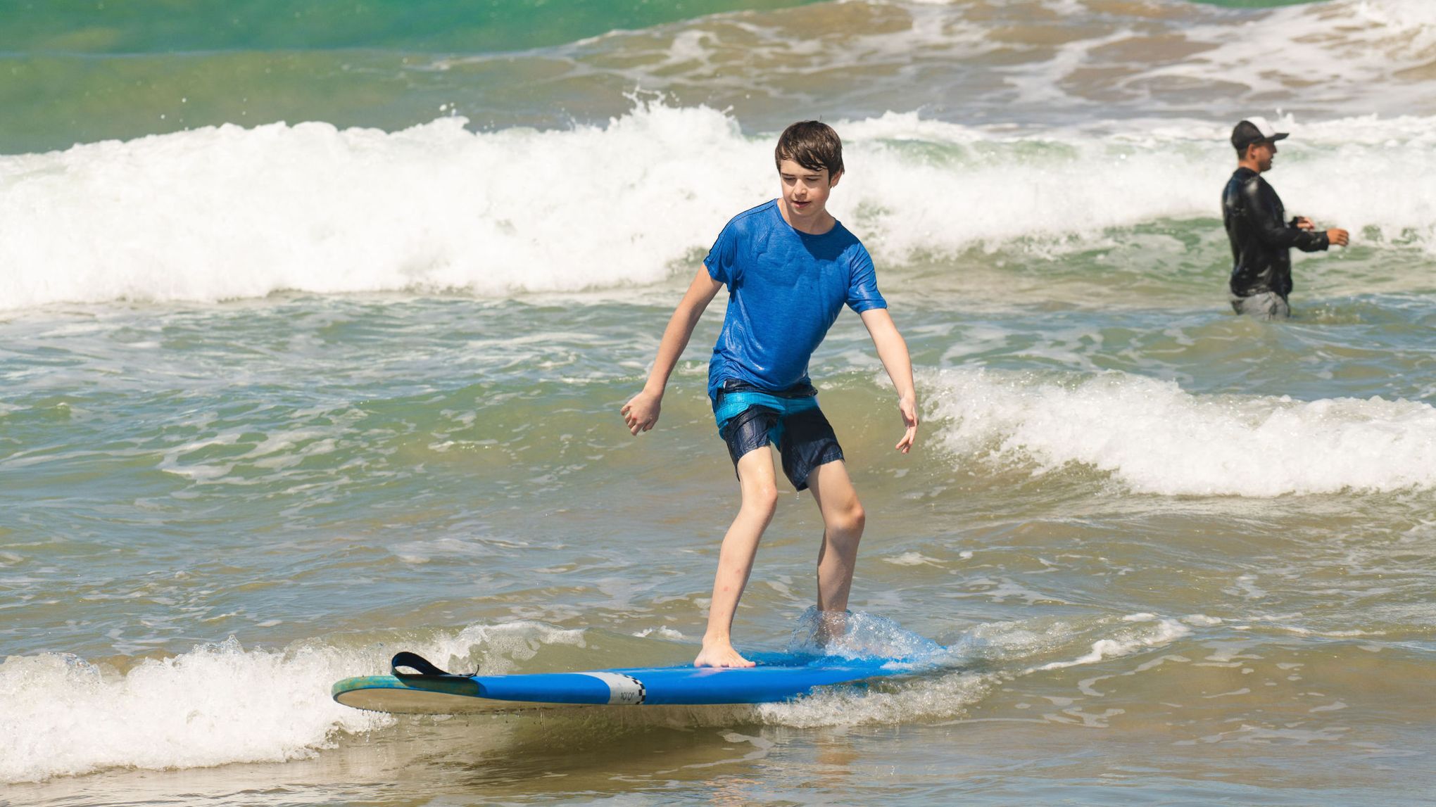 a small girl riding a wave on a surfboard in the ocean