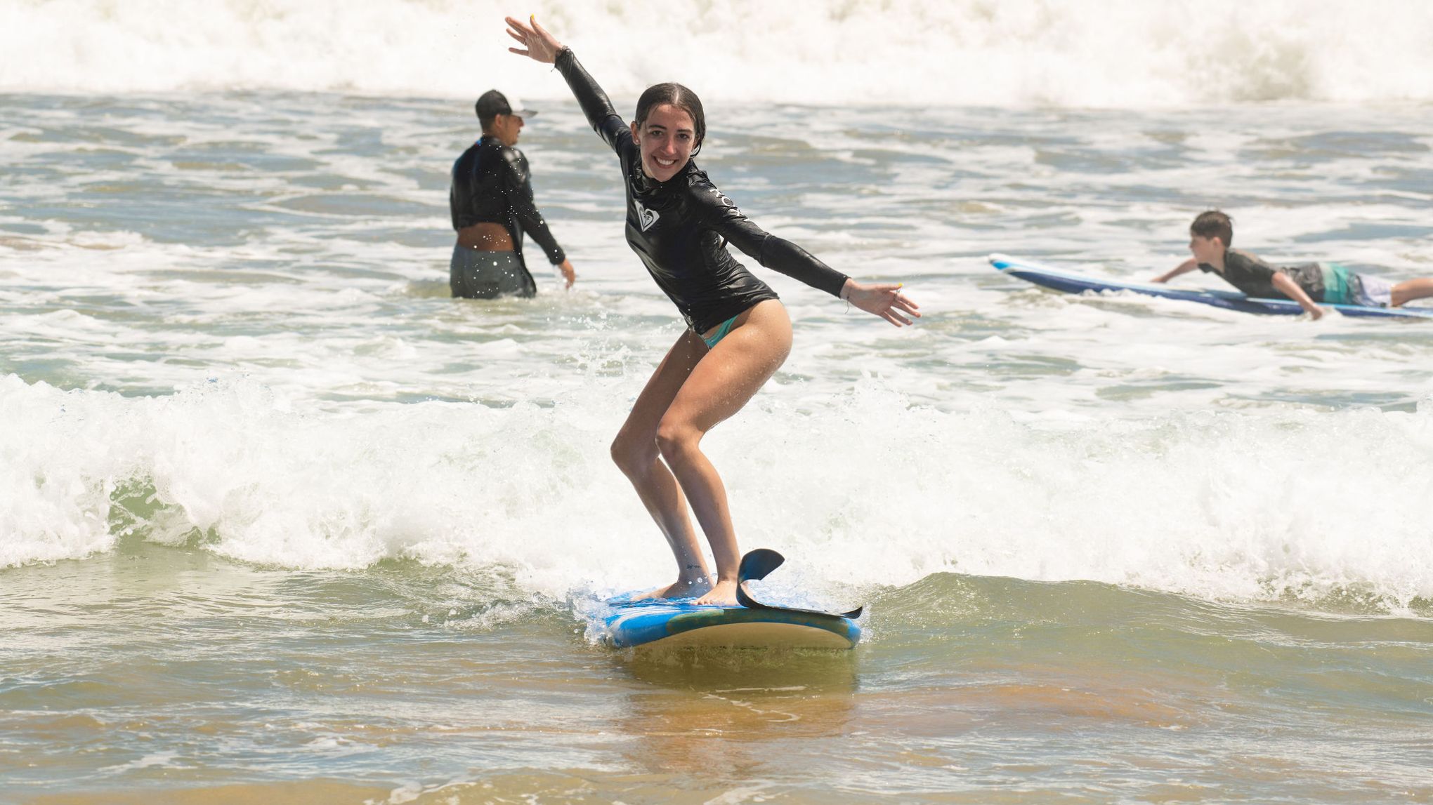 a girl riding a wave on a surfboard in the water