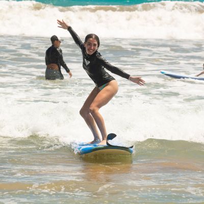 a girl riding a wave on a surfboard in the water