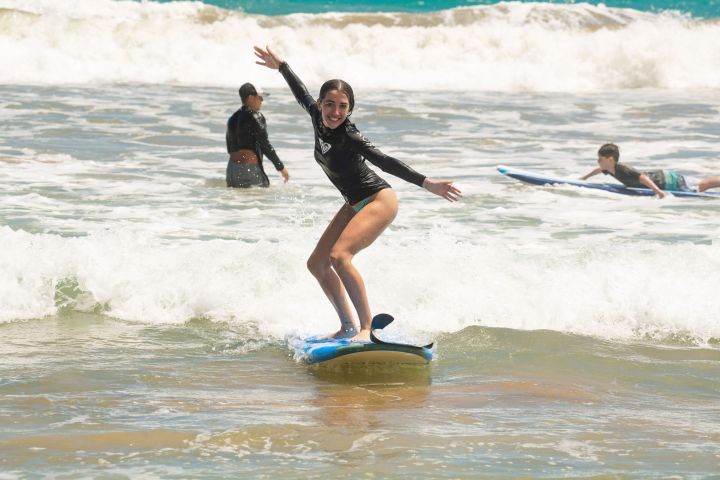 a girl riding a wave on a surfboard in the water